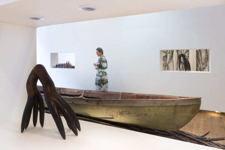 Foreground: DAUGHTER OF COMB, 2010, bronze
| Background: THEIR SPIRITS GONE BEFORE THEM, 2006, cottonwood canoe, 1357 resin figures, sugar cane, 16’; LIGNUM VITAE POINTS, 2011, 2" - 12"; ECSTATIC, 2010, lignum vitae
